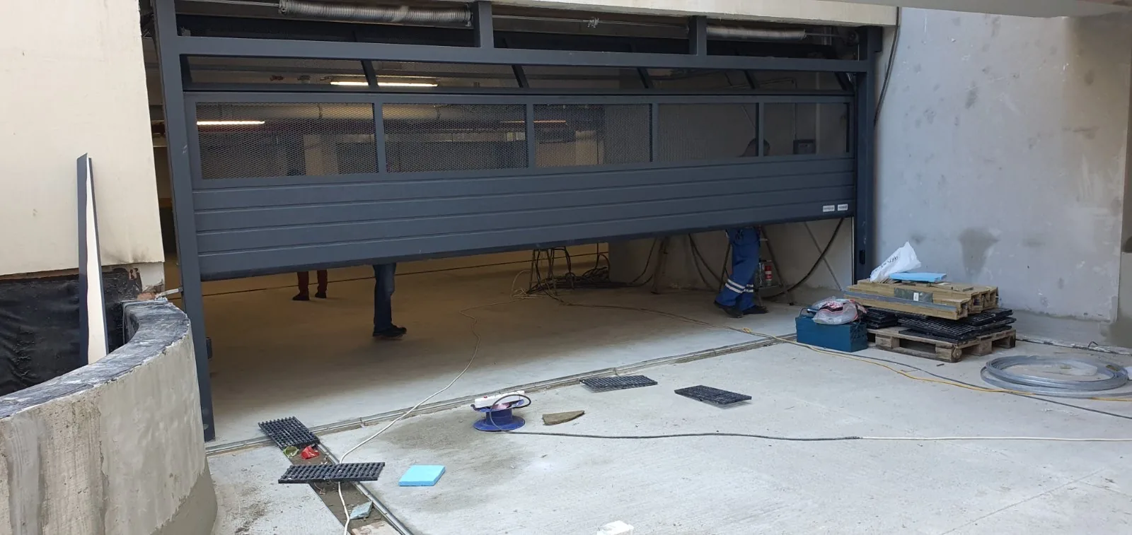 Anthracite sectional door with a transparent panel, during installation