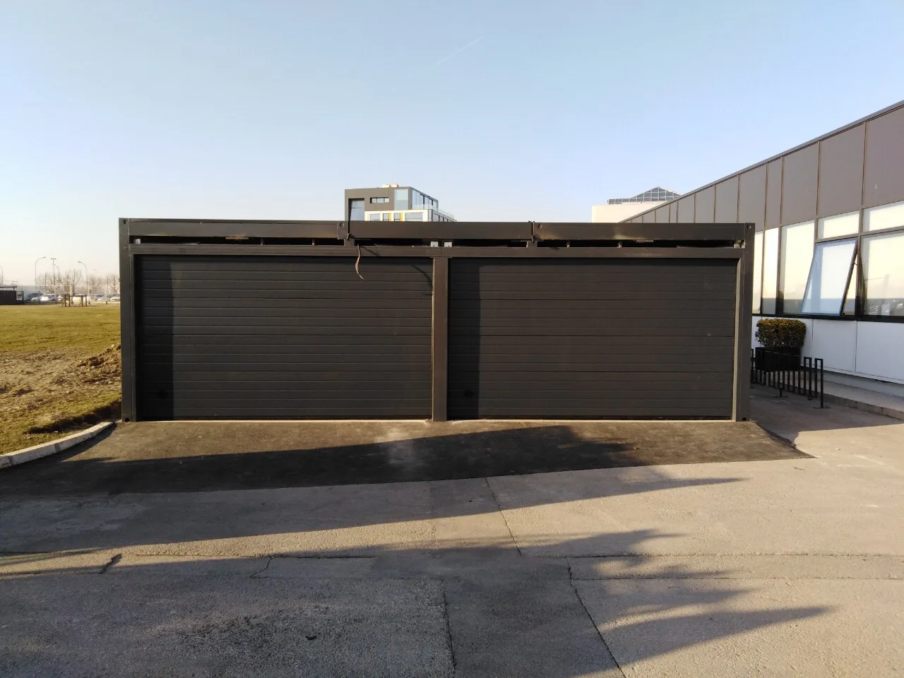 Two black sectional garage doors on a steel-frame structure