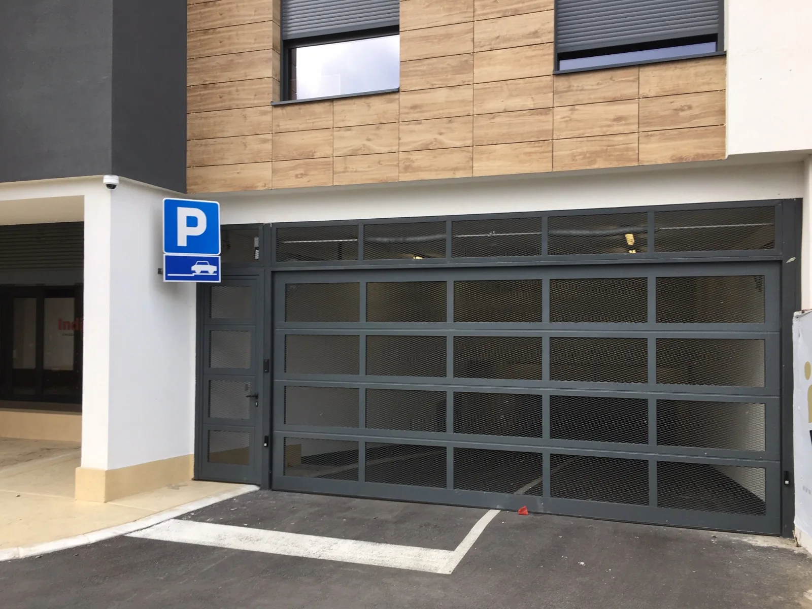 Garage door with a pedestrian door and expanded-metal panels