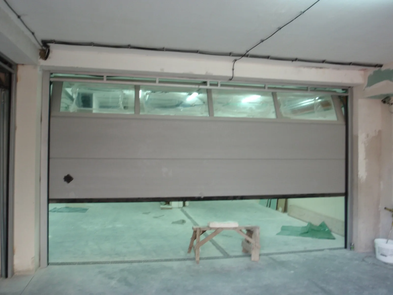 Sectional garage door with a glazed top panel