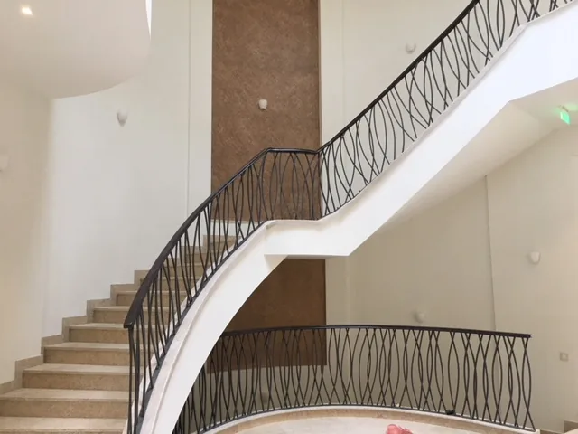 Wrought railing with a wave pattern on a curved staircase