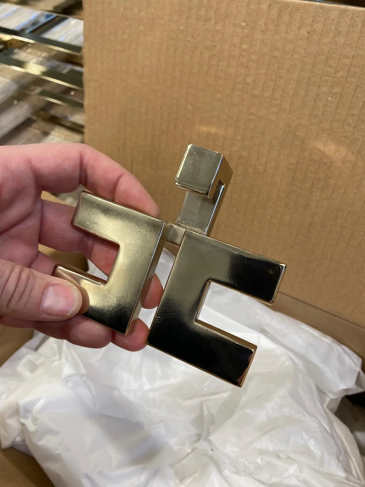 Brass hardware with crisp edges and a polished surface, packed in protective paper